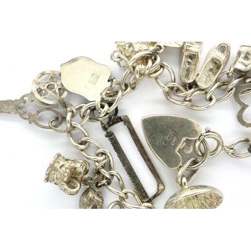 33 - Silver seventeen charm bracelet with padlock clasp, L: 21 cm, 43g. P&P Group 1 (£14+VAT for the firs... 