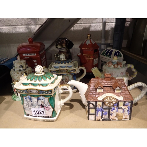 1021 - Nine novelty teapots to include a phone box example. Not available for in-house P&P