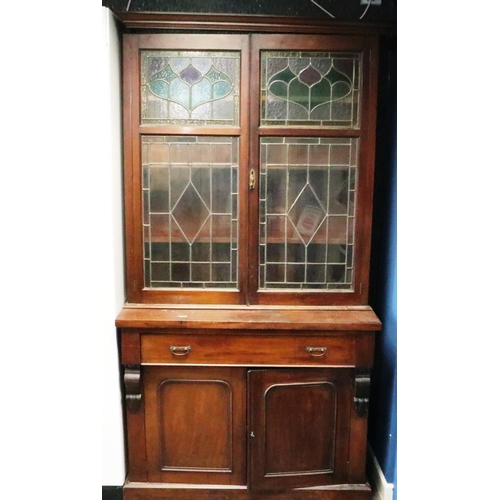 3093 - A Victorian bookcase, having two doors glazed with stained glass, three shelves raised above a sideb... 