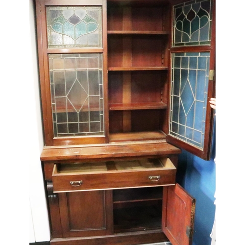 3093 - A Victorian bookcase, having two doors glazed with stained glass, three shelves raised above a sideb... 