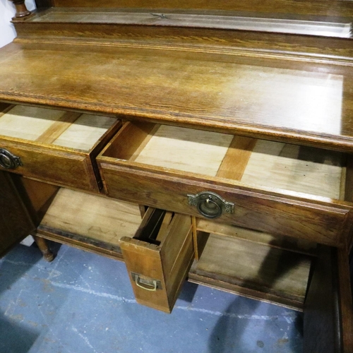 3094 - An Arts and Crafts period oak dresser with mirrored back, cupboard base and three bottle cellarette ... 