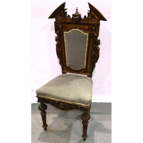 3101 - A 19th century mahogany hall chair, the backrest heavily carved with figureheads and broken pediment... 