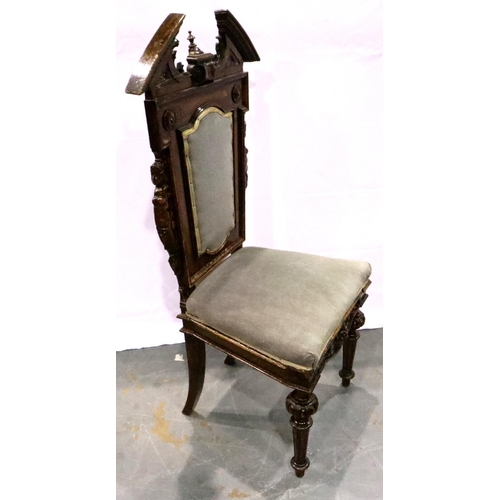 3101 - A 19th century mahogany hall chair, the backrest heavily carved with figureheads and broken pediment... 