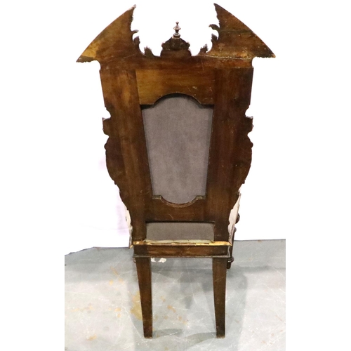 3101 - A 19th century mahogany hall chair, the backrest heavily carved with figureheads and broken pediment... 