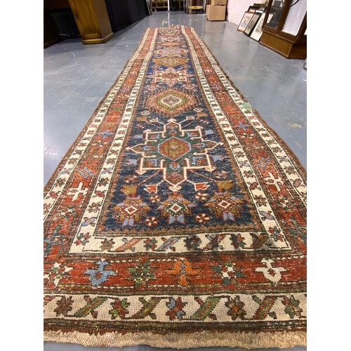 3071 - Large woollen runner, 95 x 455 cm. fading to array tassels are missing on one end, small tears to ed... 