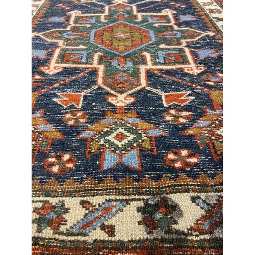 3071 - Large woollen runner, 95 x 455 cm. fading to array tassels are missing on one end, small tears to ed... 