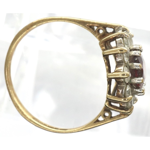 31 - 9ct gold ring set with a central garnet and CZ stones, size M, 2.1g. P&P Group 1 (£14+VAT for the fi... 