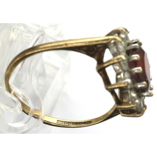 31 - 9ct gold ring set with a central garnet and CZ stones, size M, 2.1g. P&P Group 1 (£14+VAT for the fi... 