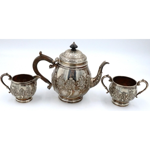 67 - A hallmarked silver three piece tea service, repousse decorated with flora and swags, London assay, ... 