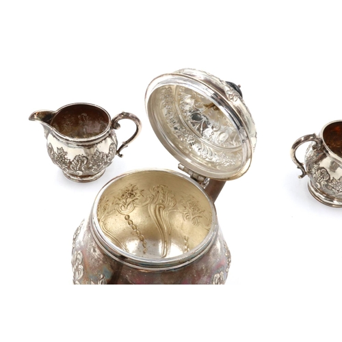 67 - A hallmarked silver three piece tea service, repousse decorated with flora and swags, London assay, ... 