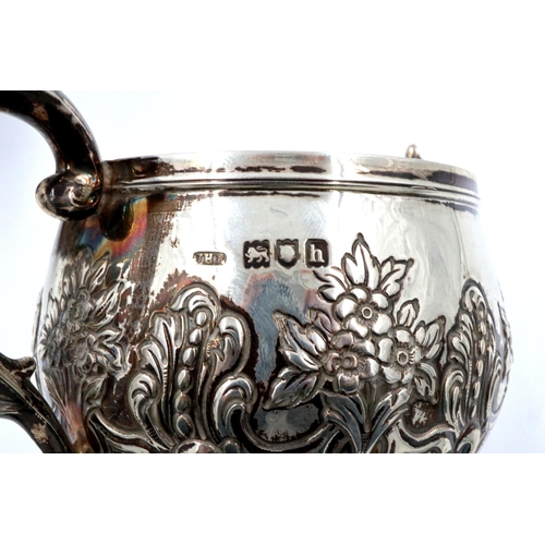 67 - A hallmarked silver three piece tea service, repousse decorated with flora and swags, London assay, ... 