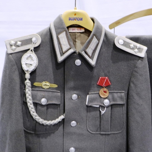 2116 - An East German NVA Armoured Division Oberleutnant tunic, with lanyard, awards, trousers and visor ca... 