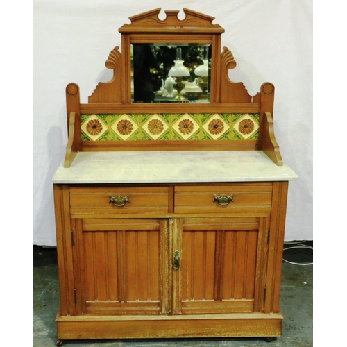 3065 - A Victorian pine washstand with marble top, tiled and mirrored upstand and a base of drawers and cup... 