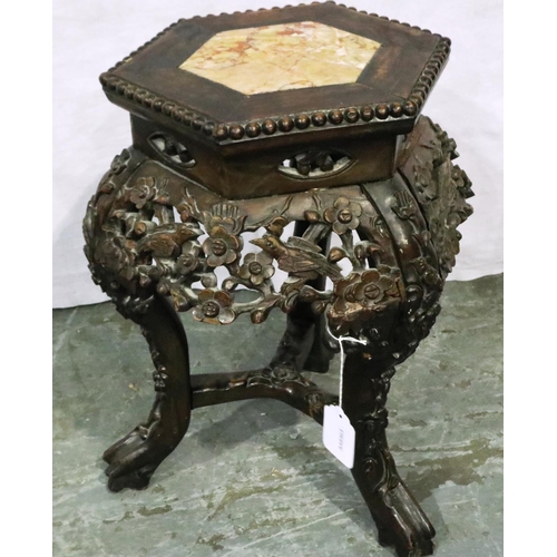 3090 - A padouk wood profusely carved vase stand, the top inset with a hexagonal panel of rouge marble, the... 