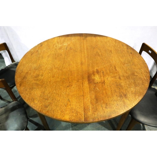 3108 - A 1960s teak circular extending dining table with integral folding leaf and a set of four chairs, ta... 