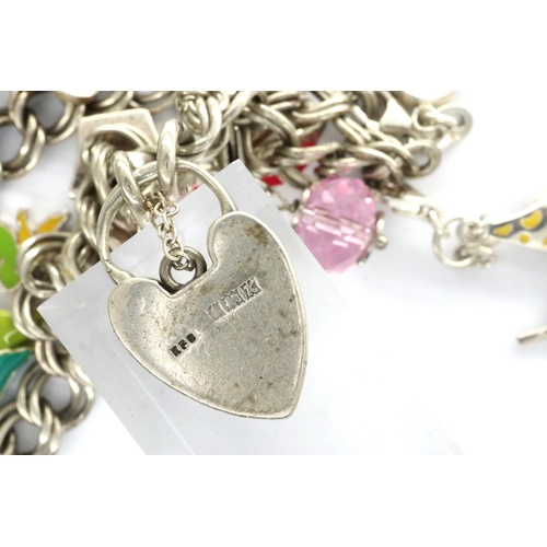 40 - Silver charm bracelet with hallmarked silver padlock clasp and eleven charms, L: 20 cm, 36g. P&P Gro... 