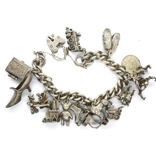 39 - Hallmarked silver charm bracelet with a hallmarked silver padlock clasp, safety chain and eighteen c... 