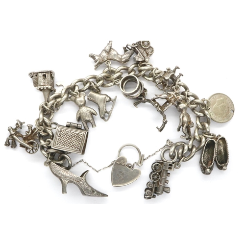 39 - Hallmarked silver charm bracelet with a hallmarked silver padlock clasp, safety chain and eighteen c... 