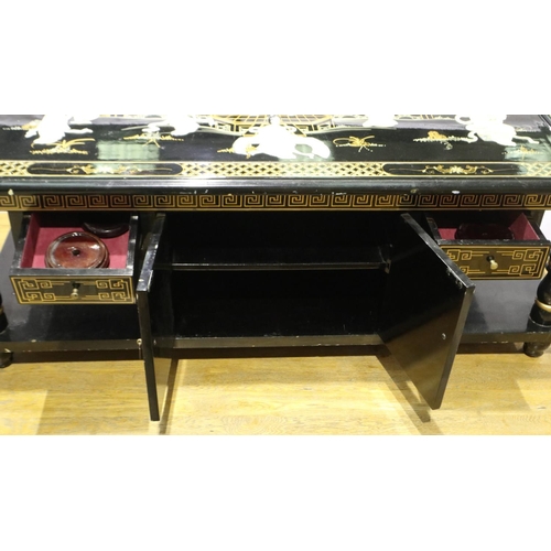 2094 - A 20th century black lacquered Oriental coffee table, glass top above a Shibyama and gilt panel with... 