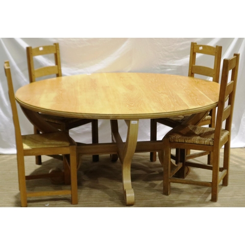 2098 - A substantial circular golden oak dining or breakfast table on a shaped quadripartide support and fo... 