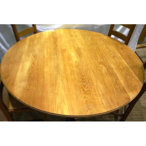 2098 - A substantial circular golden oak dining or breakfast table on a shaped quadripartide support and fo... 