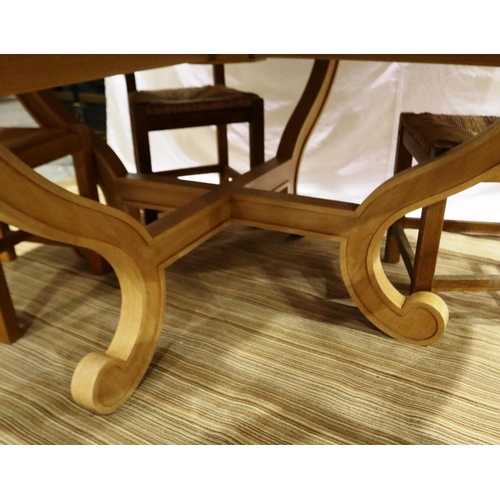 2098 - A substantial circular golden oak dining or breakfast table on a shaped quadripartide support and fo... 