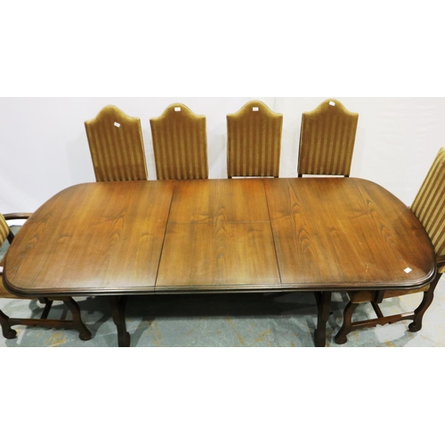 2105 - A 20th century Spanish oak extending dining table with a set of ten upholstered high back dining cha... 