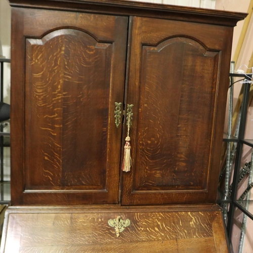 2128 - An early 19th century oak bureau bookcase with fitted interior of drawers, pigeon holes and conceale... 