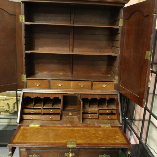 2128 - An early 19th century oak bureau bookcase with fitted interior of drawers, pigeon holes and conceale... 