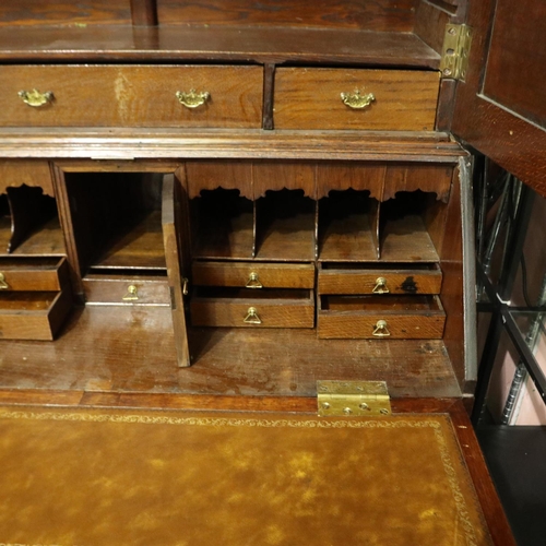 2128 - An early 19th century oak bureau bookcase with fitted interior of drawers, pigeon holes and conceale... 