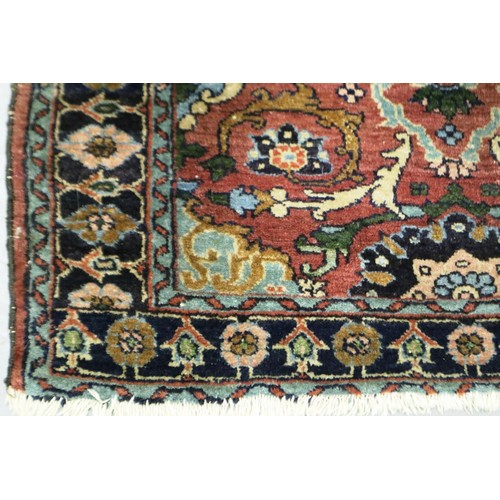 2084 - A 19th Century Eastern woollen floor rug with floral designs against a dark red ground, 145 x 90 cm.... 