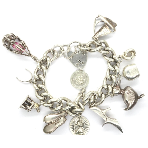 28 - Heavy gauge 925 silver charm bracelet with hallmarked padlock clasp and eleven charms, bracelet L: 2... 