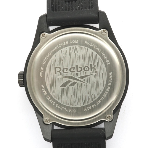 113 - REEBOK: gents quartz wristwatch, with circular black dial and rubber sports strap, working at lottin... 