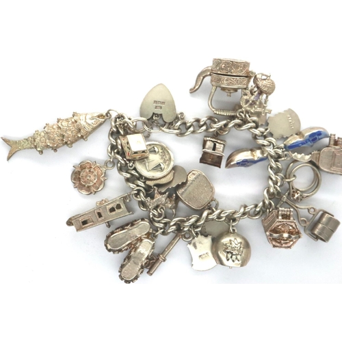 81 - Silver charm bracelet with twenty charms, 93g. P&P Group 1 (£14+VAT for the first lot and £1+VAT for... 