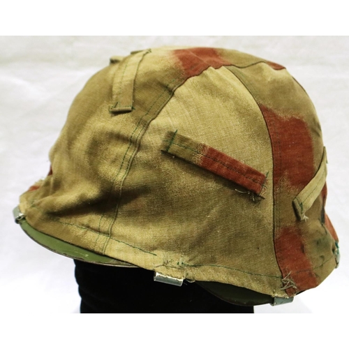 2185 - A Spanish M42 steel helmet with leather and canvas liner, with a German M35 camouflage helmet cover.... 