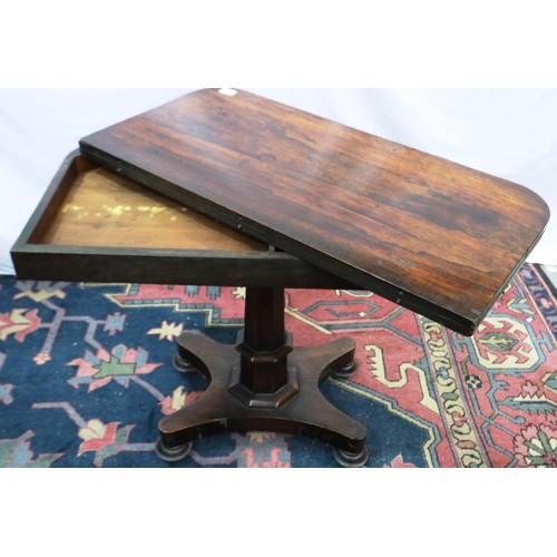 2116 - A 19th century rosewood games table with foldover top, tapering pedestal and quatrifoil support, 91 ... 