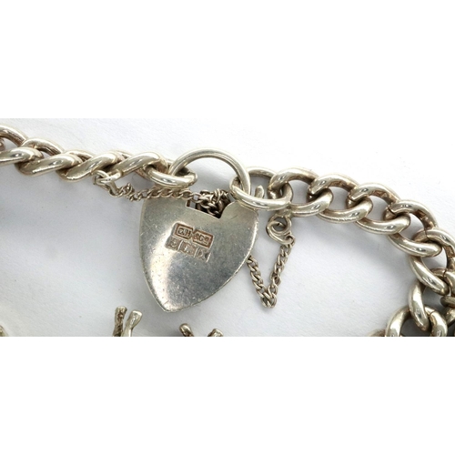 10 - Hallmarked silver charm bracelet with nine 925 silver charms, and hallmarked silver clasp, L: 18 cm,... 