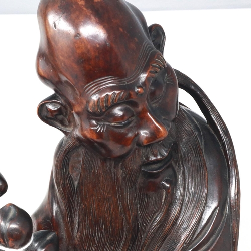 288 - Carved hardwood statue of Shou Lao (Shou Xing) Taoist God of Longevity, standing on a bat, H: 60 cm.... 