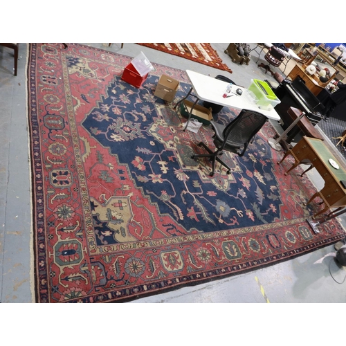 379 - Very large red ground rug with polychrome geometric design, 500 x 440 cm. Not available for in-house... 