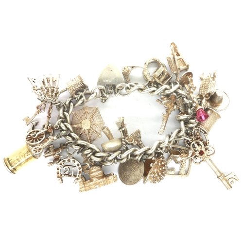 21 - Hallmarked silver charm bracelet, with 925 silver charms, L: 18 cm, 89g. P&P Group 1 (£14+VAT for th... 