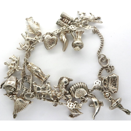 17 - Silver charm bracelet with nineteen charms, 49.2g. P&P Group 1 (£14+VAT for the first lot and £1+VAT... 