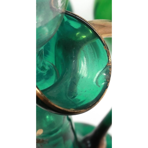 323 - Mary Gregory green glass decanter with enamelled cherub design and three similar examples with match... 