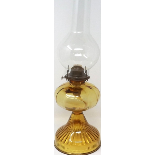 355 - An American amber glass oil lamp, with chimney, H: 53 cm. Not available for in-house P&P