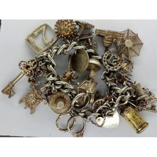 7 - Hallmarked silver charm bracelet with twenty seven charms, L: 18 cm, overall 89g. P&P Group 1 (£14+V... 