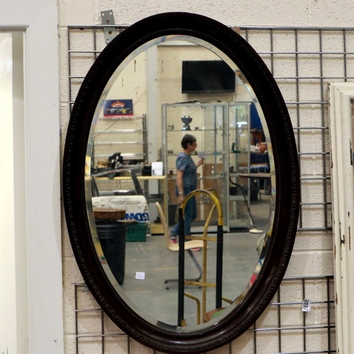 2087 - A large Victorian oval wall mirror with bevelled glass and carved mahogany frame, 100 x 70 cm. Not a... 