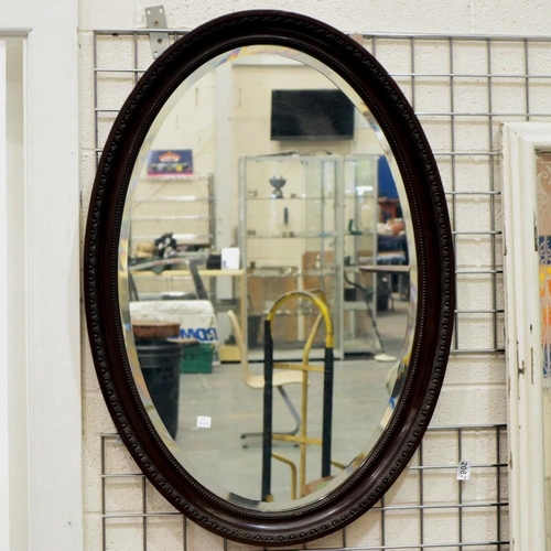 2087 - A large Victorian oval wall mirror with bevelled glass and carved mahogany frame, 100 x 70 cm. Not a... 