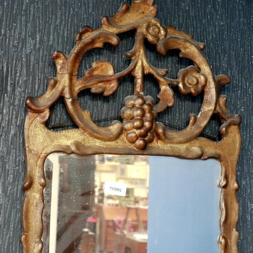 2092 - An early mid 19th century continental gilt framed wall mirror, the pediment carved with fruit and fl... 