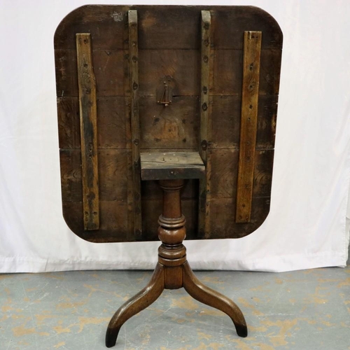 2119 - A George II provincial oak tilt top table, raised on a turned column and tripod supports, 95 x 86 x ... 