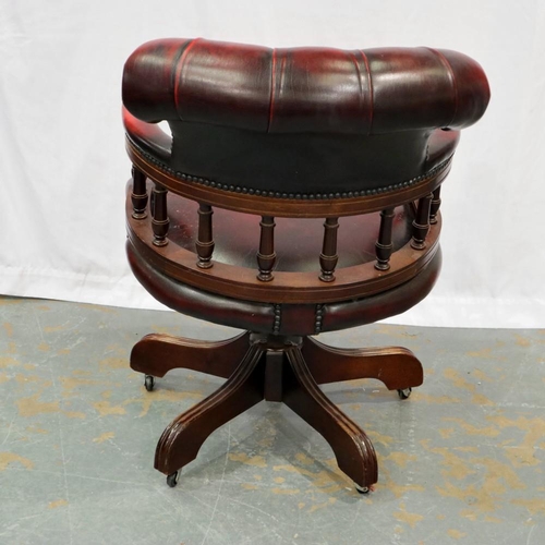 2122 - A 20th century Chesterfield style swivel desk chair, upholstered in ox blood leather on a five spoke... 