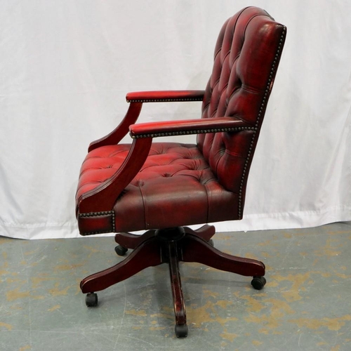 2127 - A 20th century Chesterfield style swivel desk chair, upholstered in ox blood leather on a five spoke... 